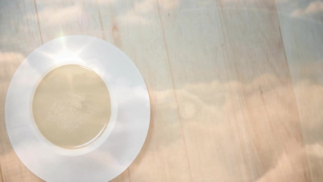 Render desain datar menunjukkan cawan dari atas berisi minuman berwarna terang di atas meja kayu dengan suar cahaya.