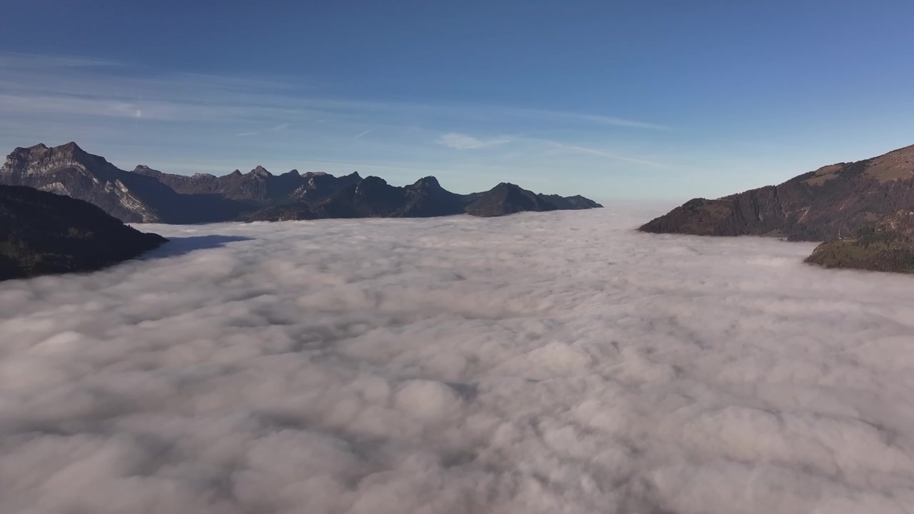 A breathtaking view above the clouds in the Swiss Alps, showcasing majestic peaks and serene atmosphere.