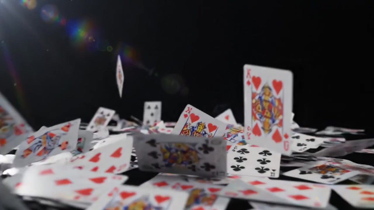 Un'Affascinante Dimostrazione di Arte Cartacea: Scene Accattivanti di Carte da Gioco che Cadono e Sparse su uno Sfondo Nero