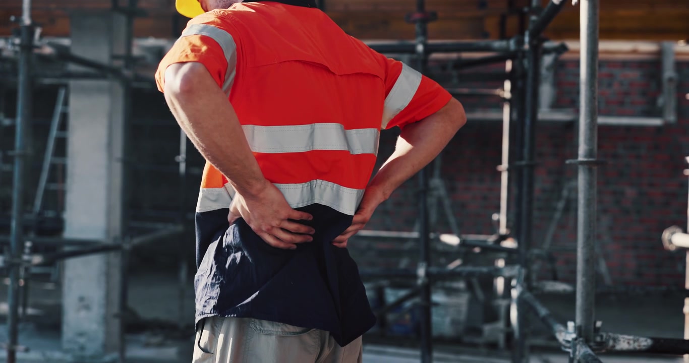 Trabajador de la construcción sufriendo dolor de espalda en la obra