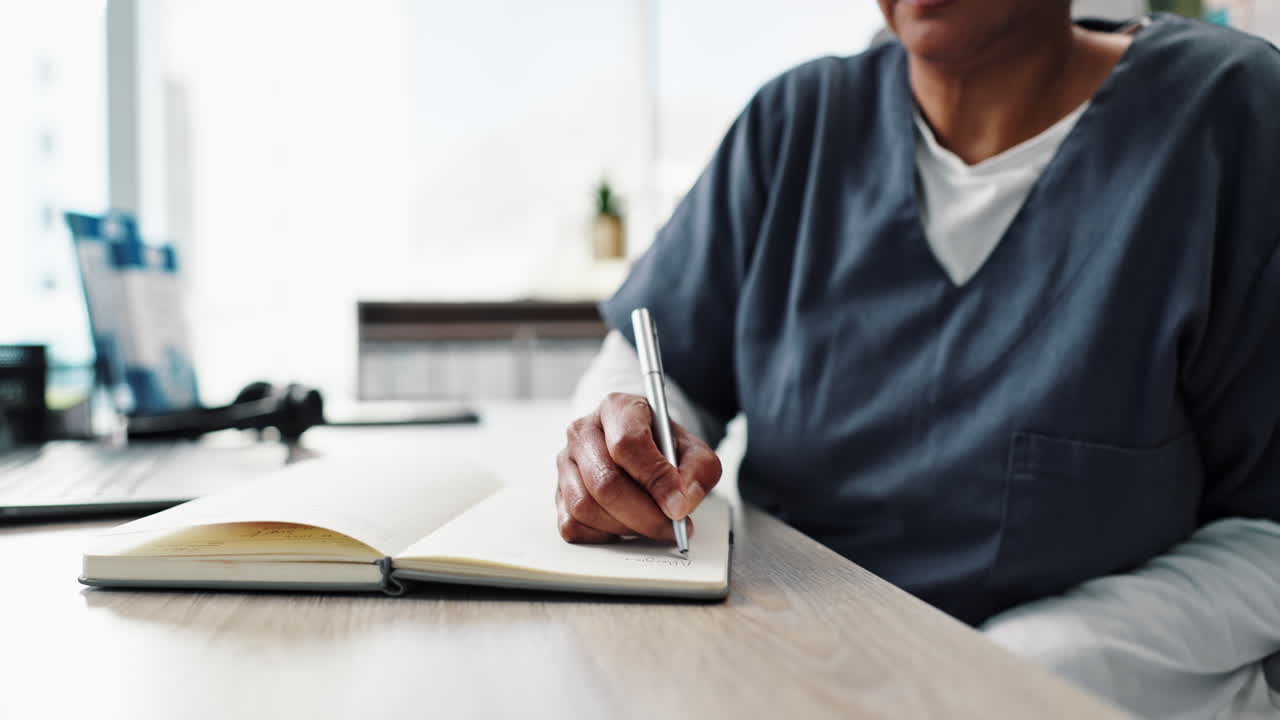 Person writing in a notebook at a desk
