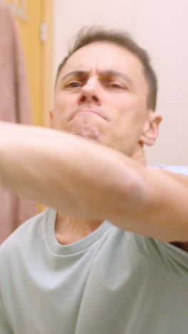 man cleaning bathroom mirror with spray and cloth