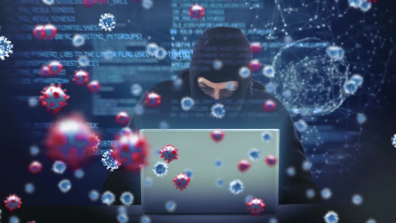 animación de las células macro covid19 sobre un hombre que lleva una balaclava, usando una computadora portátil