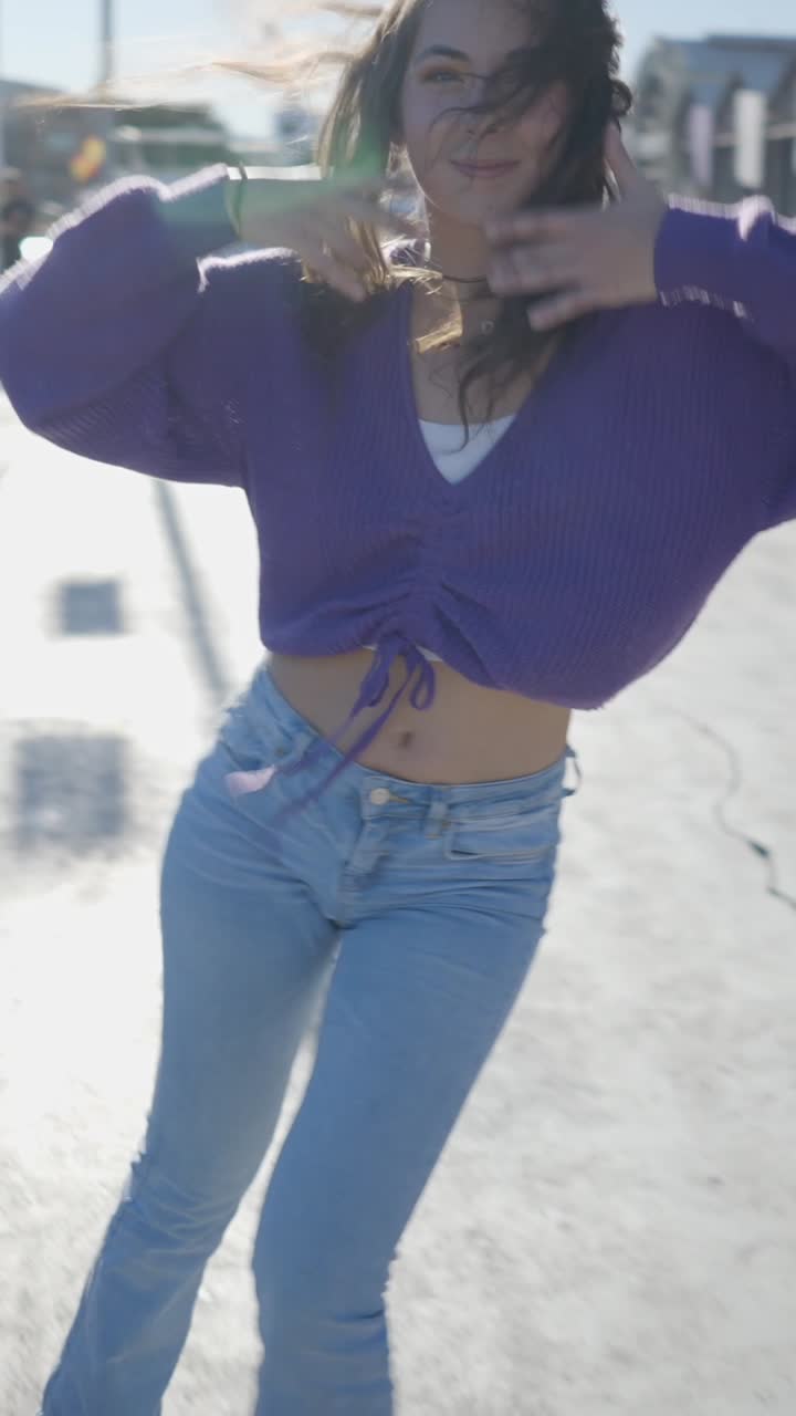 Vibrant young woman dancing energetically outdoors