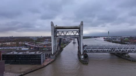 railway bridge cantilevers open to allow floating crane to sail under