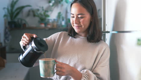 a woman pouring herself coffee from a plunger