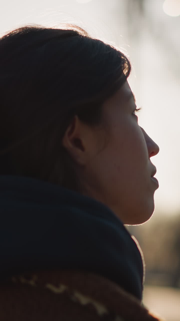 primer plano de una niña caminando con una expresión llorosa, capturando un momento de profunda contemplación y tristeza. la suave iluminación de fondo de la puesta de sol agrega una atmósfera reflexiva y emocional a la escena