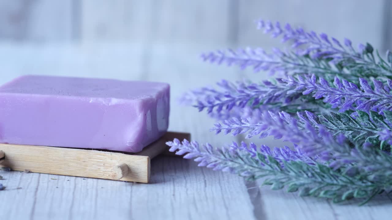 Sapone alla lavanda su supporto di legno con fiori di lavanda