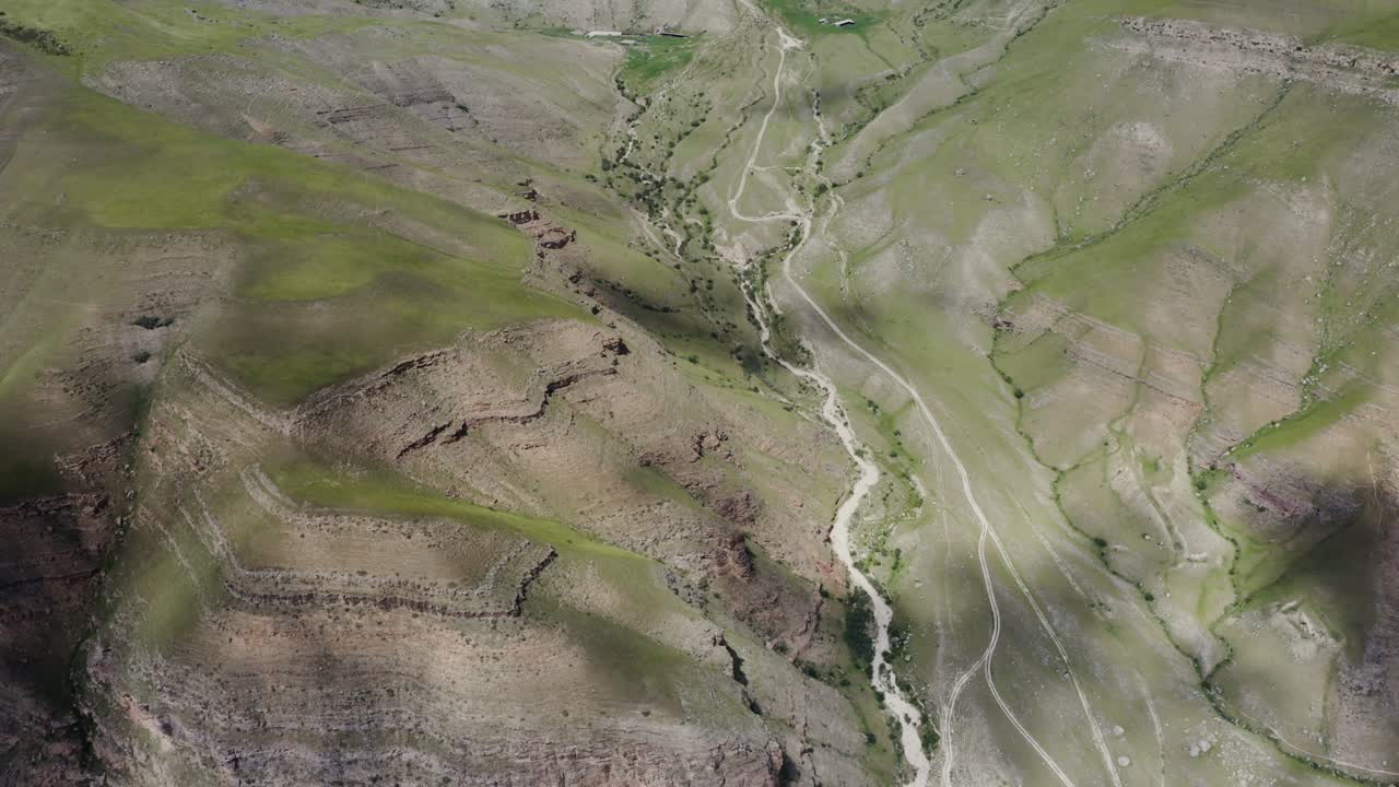 vista de ángulo alto de un valle con senderos sinuosos y montañas