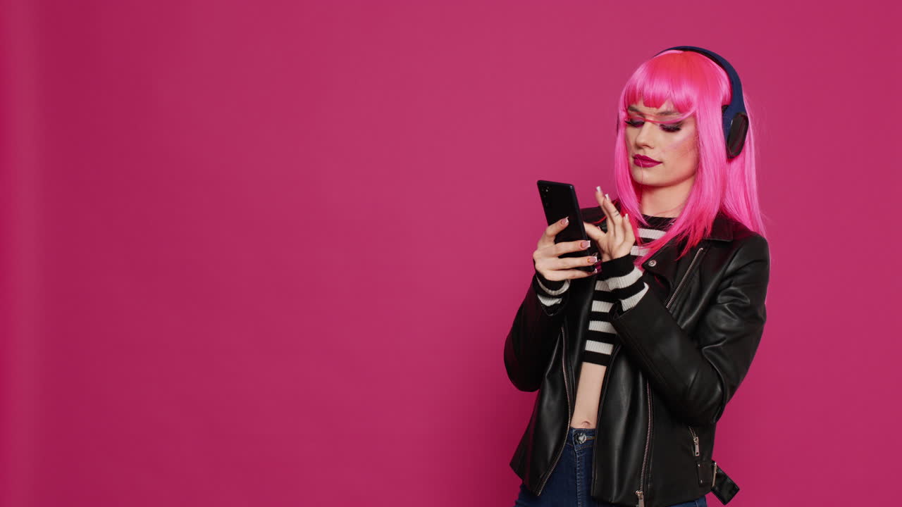 Happy beautiful girl with pink wig texting messages