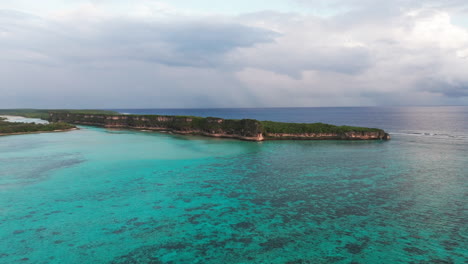 wide aerial panorama of lekini bay, ouvéa, new caledonia, showing turquoise reef waters and lush island vegetation
