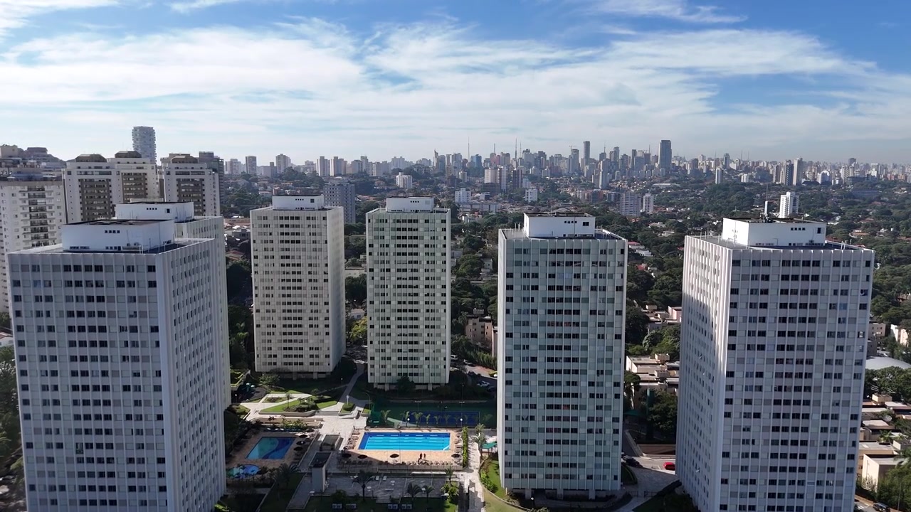Vuelo cinematográfico de dron hacia adelante sobre un denso horizonte de edificios de gran altura en un día soleado con un cielo azul claro en un distrito exclusivo de São Paulo, Brasil. Metraje aéreo de paisaje urbano