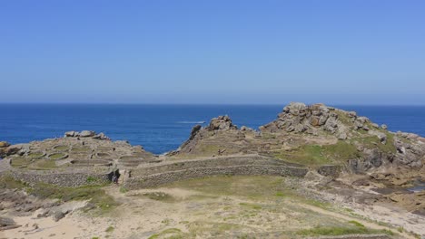 People-visiting-the-historic-fortress-of-Castro-de-Baroña,-Aerial