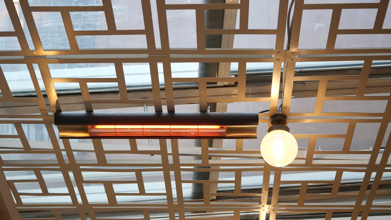 cerca de un calentador y un accesorio de luz en un techo con un patrón de cuadrícula metálica