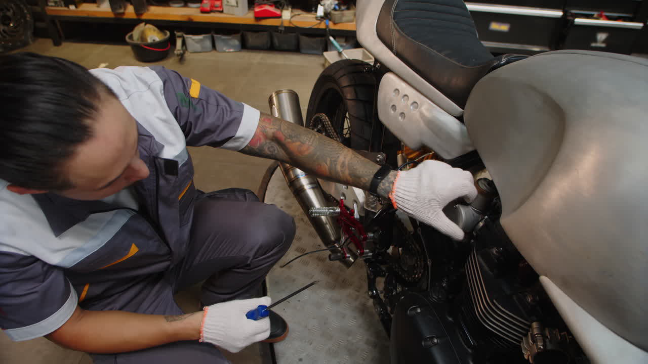 Multicultural Mechanic Using Screwdriver while Repairing Vehicle