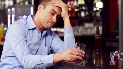 un hombre de negocios preocupado tomando una copa.