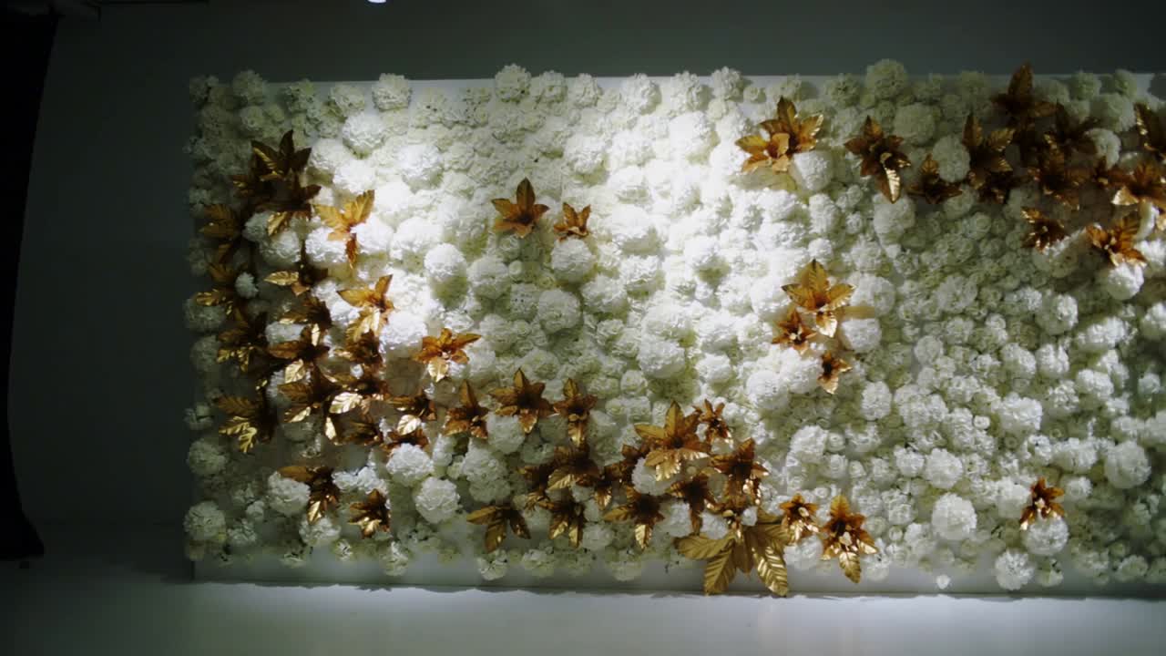 Shifting spotlight lighting floral panel in gallery, showing gold ornaments, white blooms