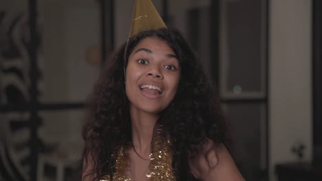 portrait of a pretty black girl making funny faces, dancing, throwing confetti at christmas party