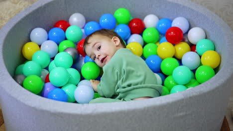 toddler playing in a colorful ball pit