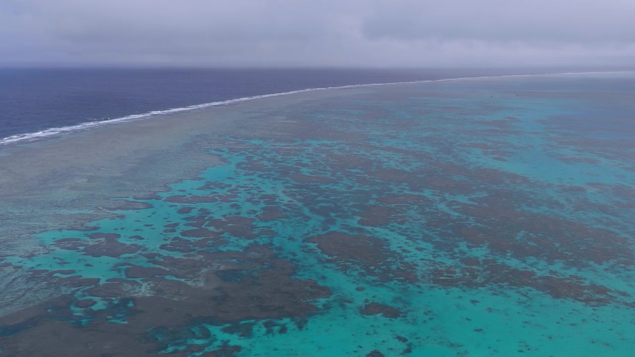 Horizontale Luftaufnahme, die direkt über dem ausgedehnten Korallenriff und dem türkisfarbenen Wasser vor Hirano Beach nahe dem Leuchtturm Hirakubozaki, Ishigaki Insel, Okinawa, Japan, schwebt