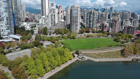 drone shot of a park by downtown vancouver buildings