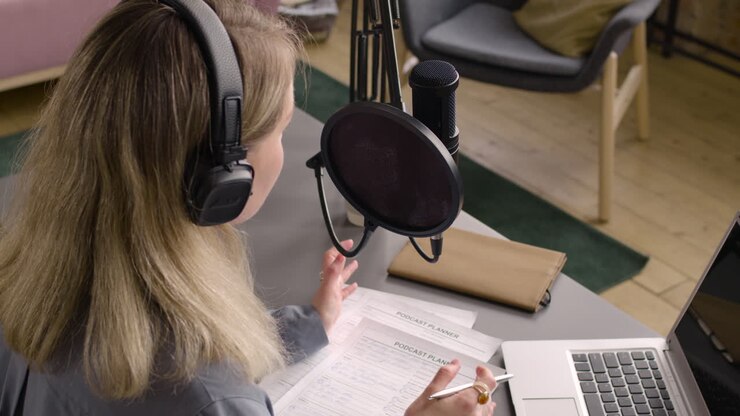 Vista dall'alto di donna che registra un podcast con le cuffie