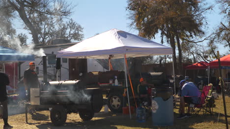 a team tent and bbq pits at a bbq cook off competition. wide shot 4k.