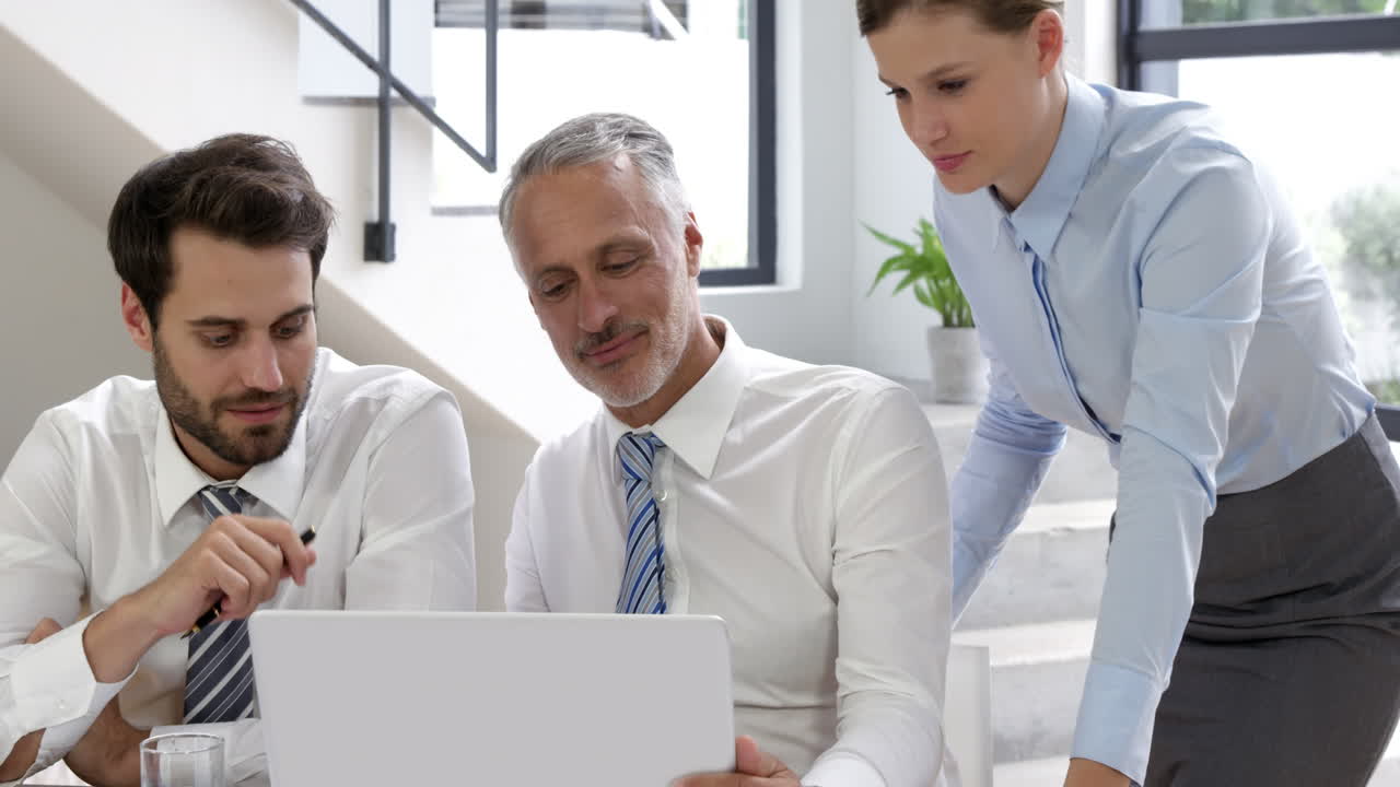 hombre de negocios y mujeres hablando frente a una computadora portátil