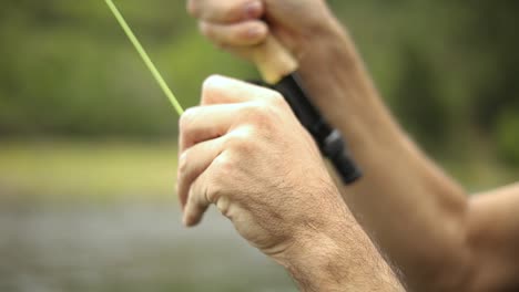 Slow-Motion-Shot-of-a-male-fisherman-wearing-waders-while-Fly-Fishing