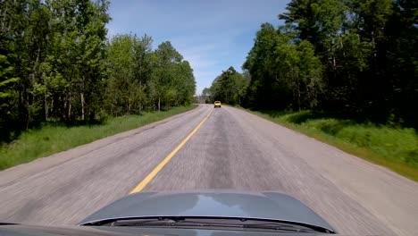 conduciendo detrás de una camioneta amarilla en la carretera trasera en cámara lenta, punto de vista amplio del techo corredizo en 4k
