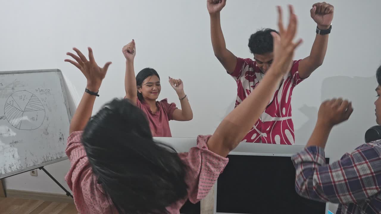 Mahasiswa Asia yang Bahagia Saling Tos dan Bersorak atas Keberhasilan Mereka di Kelas Komputer
