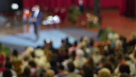 crowd of people to sitting and listening in a large hall