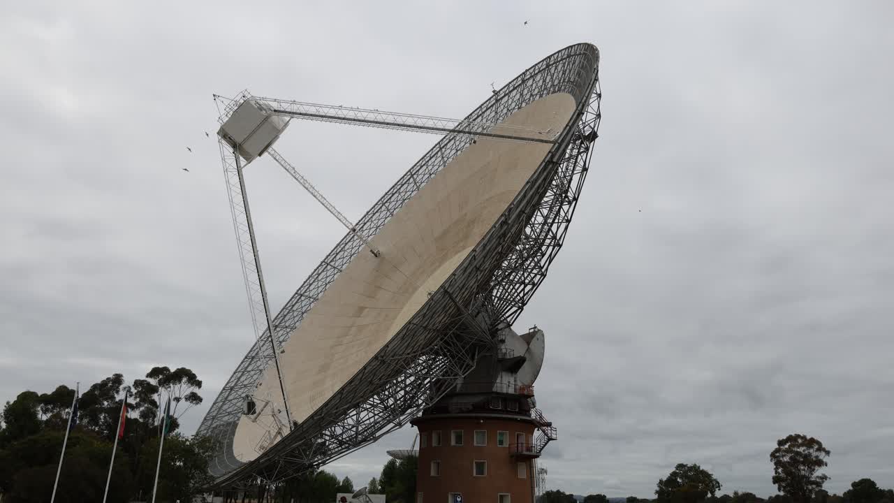 la antena parabólica gira contra un cielo nublado