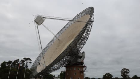 satellite dish rotates against a cloudy sky