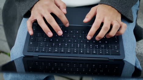 student hands working keyboard outdoor closeup. unknown man typing laptop device