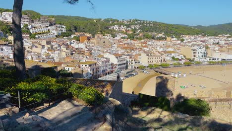 Tossa-de-Mar-bay-seen-from-the-castle-to-the-beach-with-coarse-sand-and-turquoise-blue-sea-water-old-walled-medieval-fishing-village-Mediterranean-sea