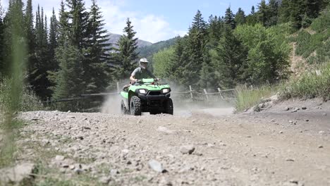 shot of an atv rider driving his quad really fast around a corner, leaving a large dirt cloud behind him-1