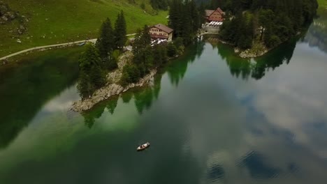 Rudern-Sie-Mit-Einem-Boot-In-Einem-Wunderschönen,-Ruhigen-See,-Umgeben-Von-Viel-Grünem,-Klarem-Wasser