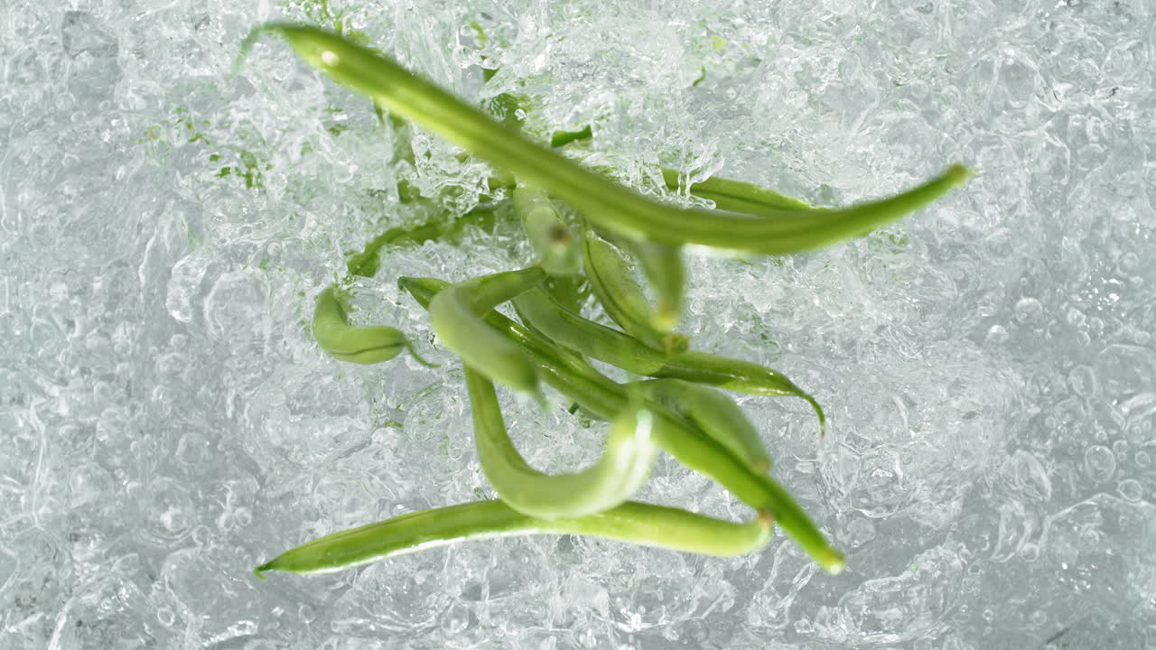 녹색 콩이 는 물의 비에 떨어지고 느린 동작으로 스플래시를 만들고, 테이블  뷰