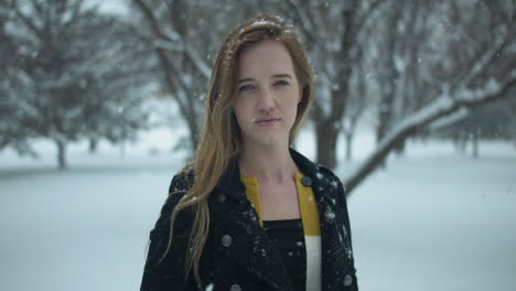 mujer feliz afuera en cámara lenta nieve de invierno como copos de nieve caen en cámara lenta cinematográfica