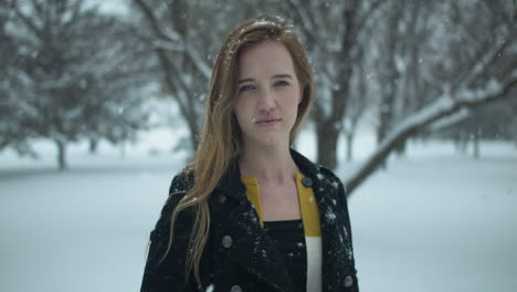 happy woman outside in slow motion winter snow as snowflakes fall in cinematic slow motion