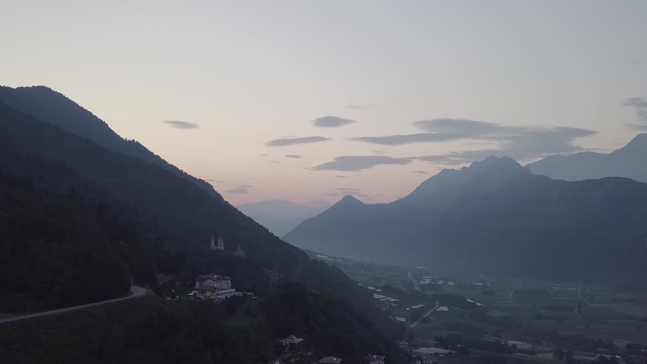 vista aérea de levico terme, italia durante el amanecer con drones volando hacia adelante