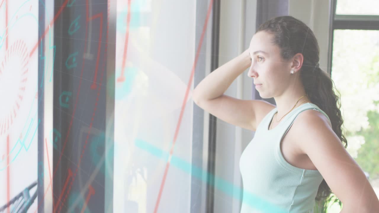 Woman standing at glass panel with holographic charts shifting, scanning analytics for insights