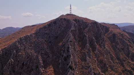 aerial view of a rugged mountain peak with a communication tower