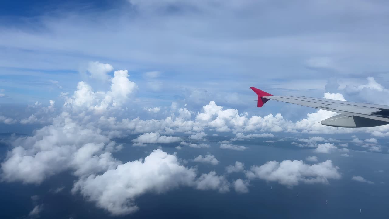 Airplane wing view with clouds on a sunny day, feeling peaceful