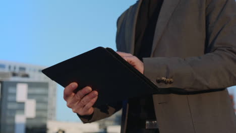 Businessman-hands-working-on-digital-tablet-at-street.-Employee-using-touchpad