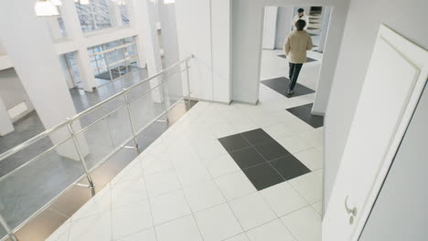 people walking through a modern, bright office building lobby
