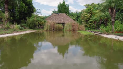 captivating-aerial-view-as-the-camera-glides-forward,-revealing-a-charming-cabana-overlooking-a-serene-river