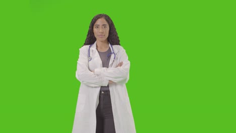 studio portrait of woman wearing christmas jumper against green screen smiling at camera