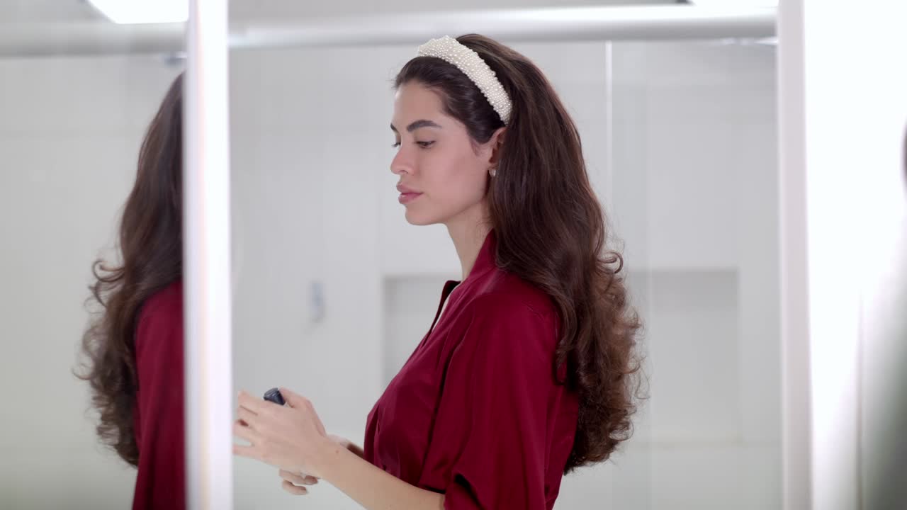 Splendida giovane modella bruna si trucca con grazia.